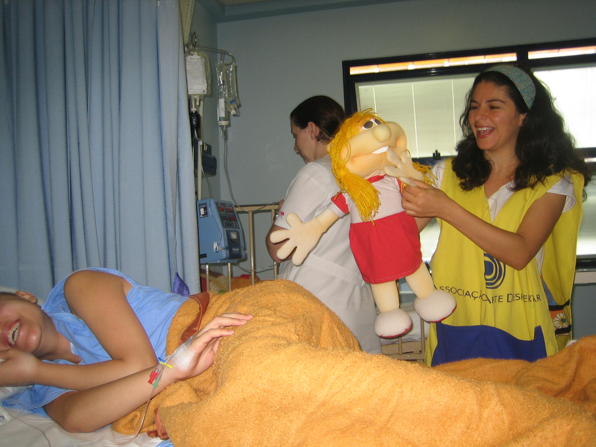 Arte-educadora conta história usando boneco no atendimento em hospitais.